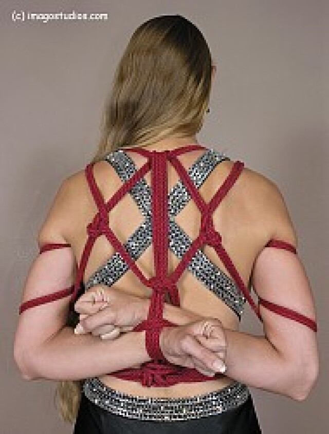 the girl has her hands tied behind her back